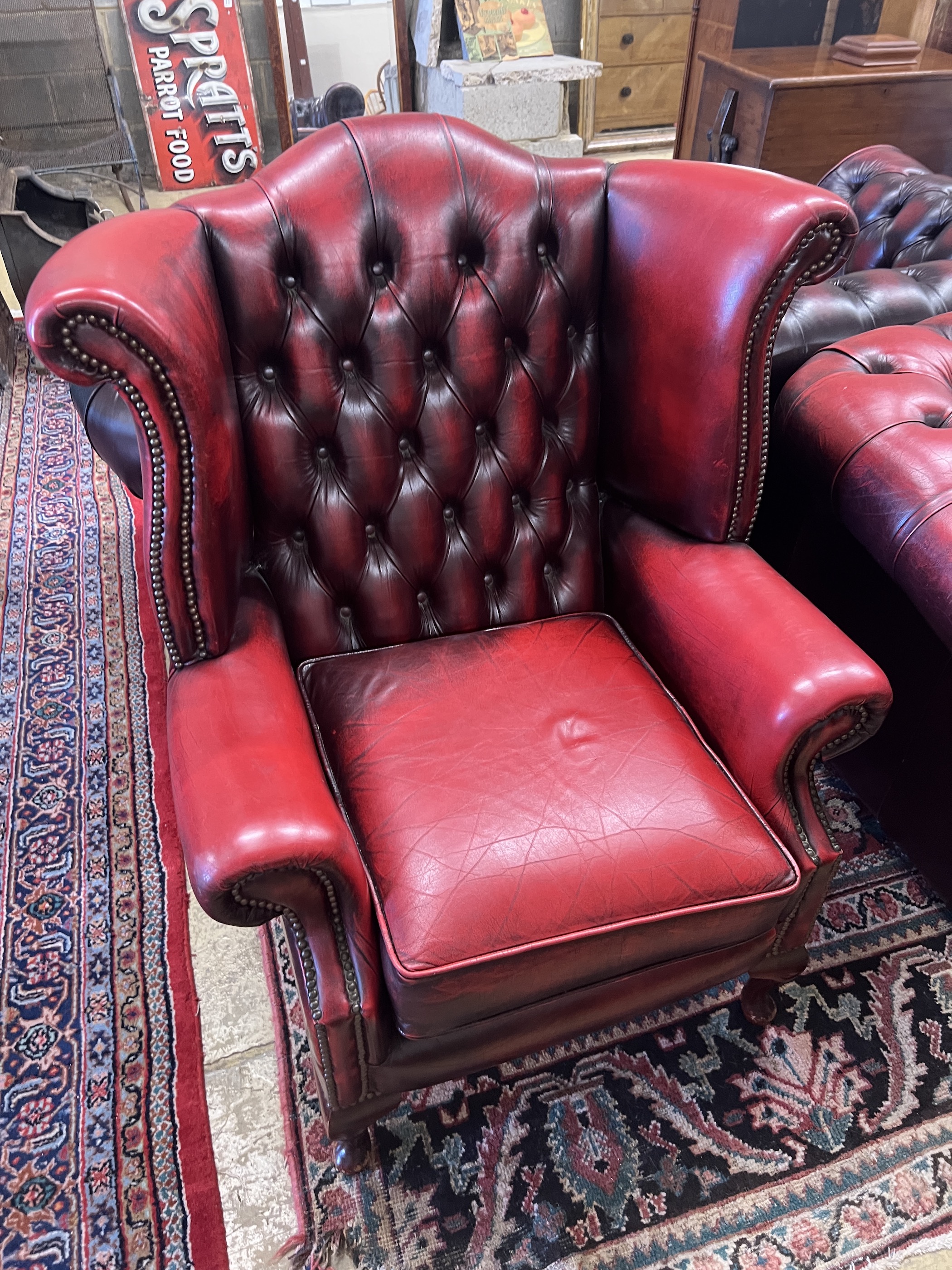 A Thomas Lloyd buttoned burgundy leather Chesterfield sofa, length 200cm, depth 85cm, height 72cm, two leather armchairs and a footstool